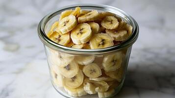 A glass jar filled with neatly arranged banana slices. photo