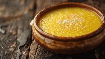 A creamy dessert in a rustic bowl, showcasing a smooth, yellow texture. photo