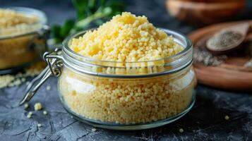A glass jar filled with couscous, showcasing its fine texture and culinary use. photo