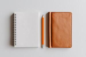 A clean flat lay of a pencil and blank notebook on a white surface, symbolizing simplicity and creativity photo