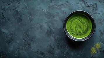 Cup of matcha tea on the stone surface, top view photo