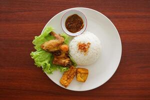 A plate with rice, chicken, and vegetables photo