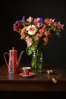 Photo still life in Dutch style with colourful flowers and a teapot and a pipe