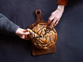 Hands taking pieces of a pie dark background copy space photo