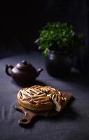 A fruit cake or a muffin or a pie with a clay pot and herbs. Flat lay. photo