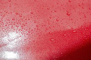 Rain water droplets with bright red color background suitable for wallpaper photo