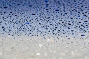 Water droplets on a dark blue ocean color background with customizable space for text or ideas photo