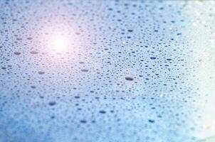 Water droplets on an ocean blue color background with customizable space for text or ideas photo