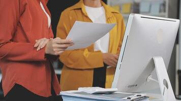 Two women are standing in front of a computer video