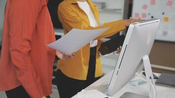Two women standing in front of a computer video