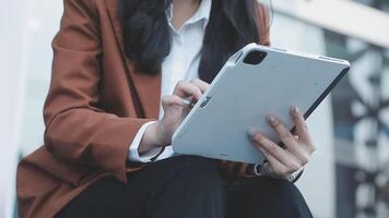 A woman in a business suit is using a tablet video
