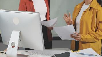 Two women standing in front of a computer video