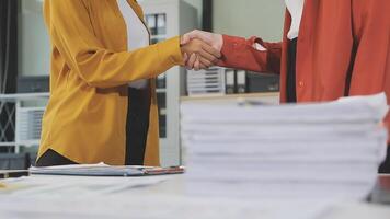Two business people shaking hands over a desk video