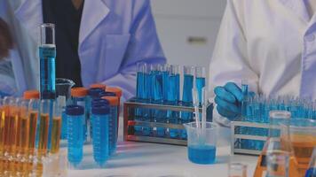 Two people in lab coats working with test tubes video