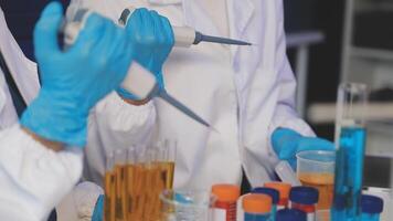 Two people in lab coats and gloves are working on something video