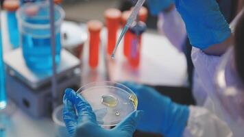 A person in a lab coat is holding a test tube video