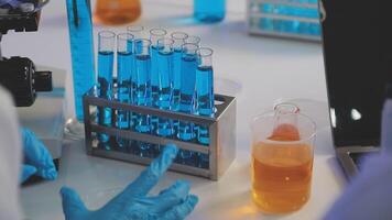 A person in a lab coat is holding a test tube video