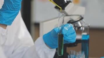 A person in a lab coat is holding a test tube video