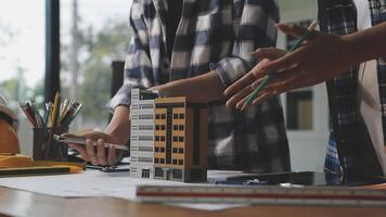 Two people working on a model of a building video