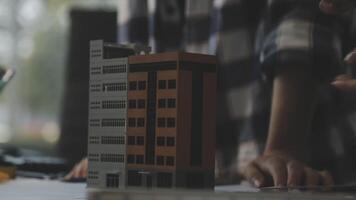 A person is working on a model of a building video