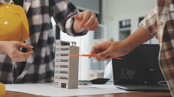 Two people working on a model of a building video