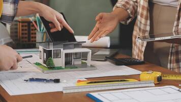 A man and woman are working on a model of a house video