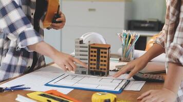 Two people working on a model of a building video