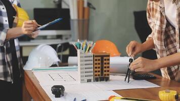 Two people working on construction plans at a desk video