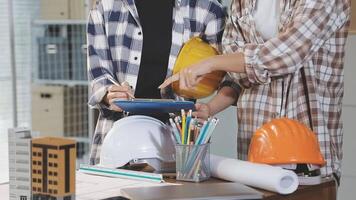 Two people in hard hats and plaid shirts working on a project video