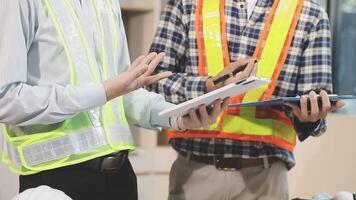 Two construction workers are standing in front of a table video