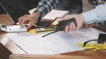 A man holding a cell phone and a tool on a table video