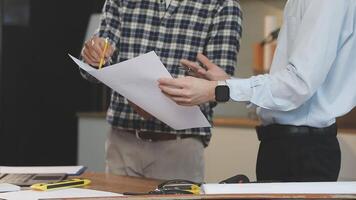 Two men standing around a table with papers video