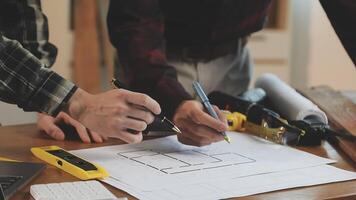 Two men working on a blueprint at a table video