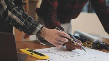Two people working on a blueprint on a table video