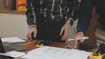 dois homens trabalhando em uma projeto às uma escrivaninha video