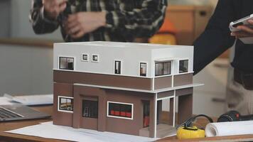 Two men are working on a model of a house video