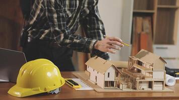 A man is working on a model of a house video