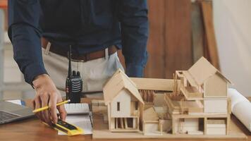 A man is working on a model of a house video