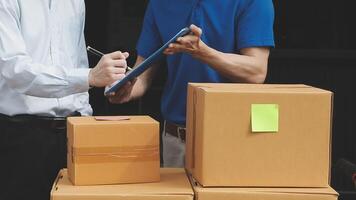 Two men are holding a clipboard and looking at a box video