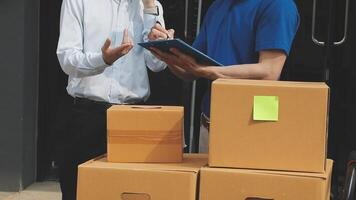 Two men standing near boxes with a tablet video