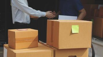 Two men shaking hands near a stack of boxes video