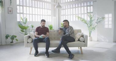 Two men on a couch interview scene talking podcast video