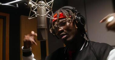 A man with dreadlocks in a recording studio video