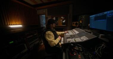 A man in a recording studio with a keyboard and monitor video