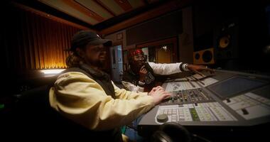 Two men in a recording studio with a mixing board video