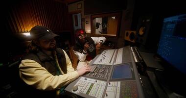 Two men in a recording studio with a computer video