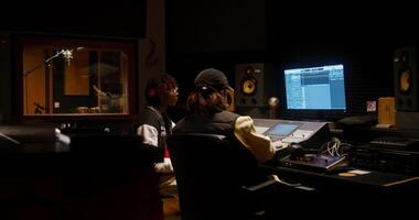 deux gens dans une enregistrement studio avec une ordinateur et microphone video
