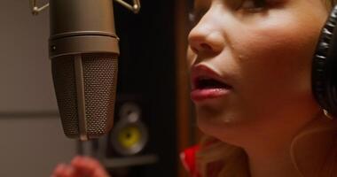 A woman singing into a microphone in a recording studio video