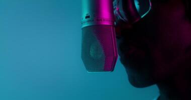 A man with sunglasses and a microphone in front of a blue background video