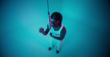 A man holding a pole in front of a blue light video